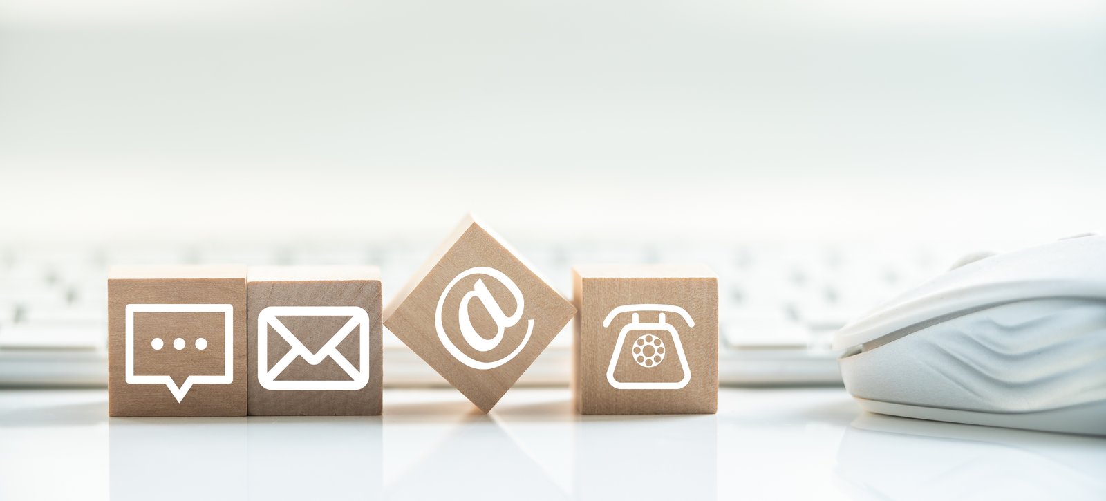 Ansprechpartner*innen für Studierende Vier Holzwürfel mit Symbolen für Sprechen, Brief, Mail, Telefon