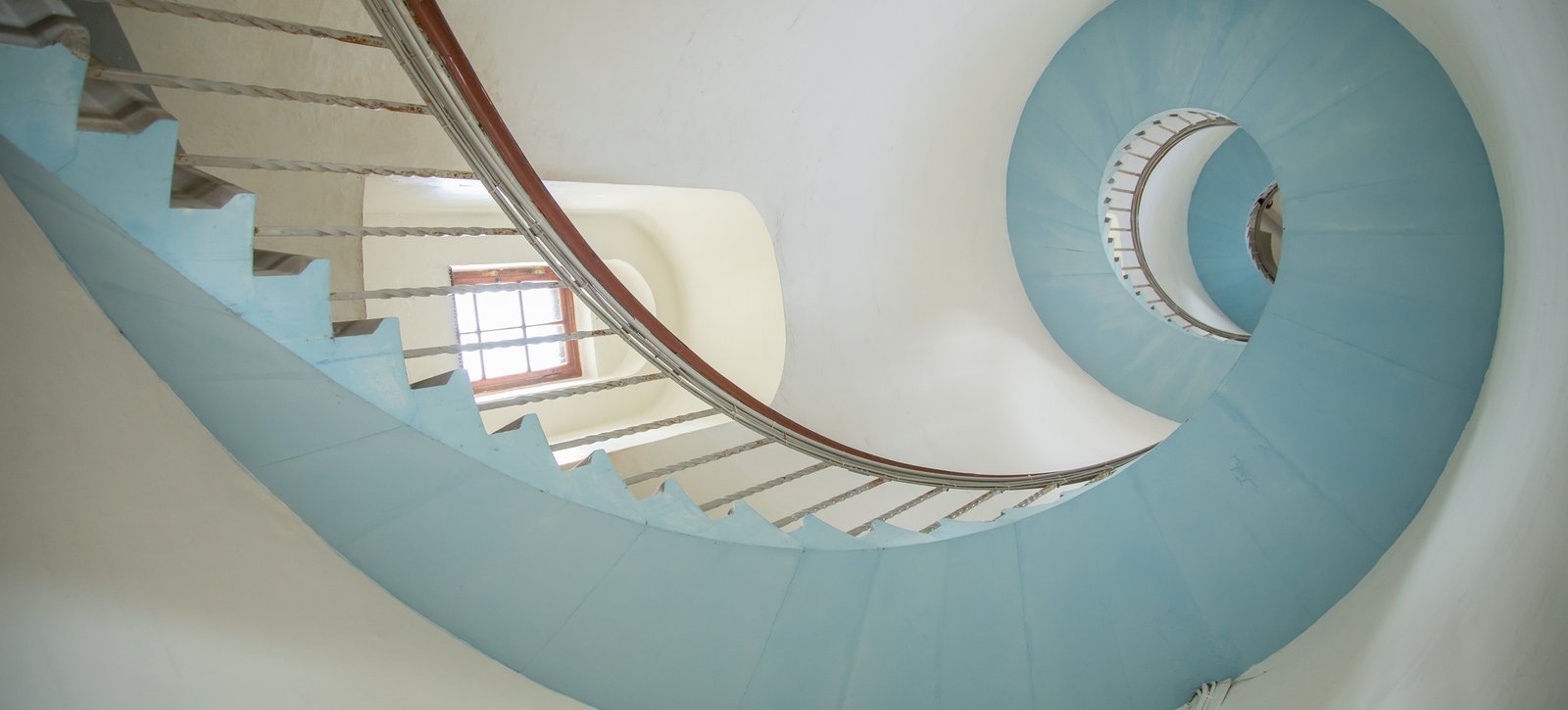 Promotion Blick nach oben auf gewundene Treppe im Leuchtturm